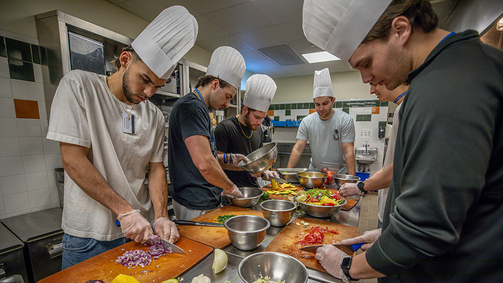 photo of a group of DPT students preparing food in a culinary lab
