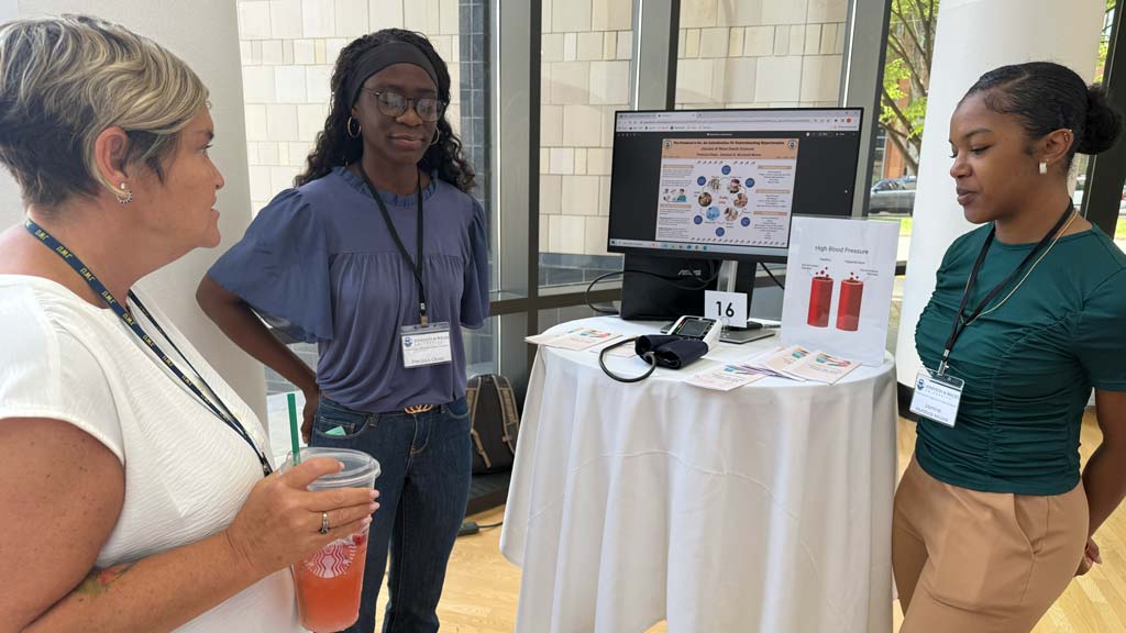 Two students presenting their project to people passing by